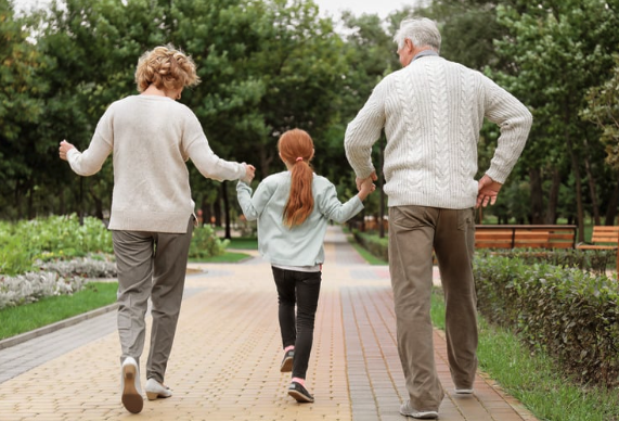 Grandparents with their grandchild walking