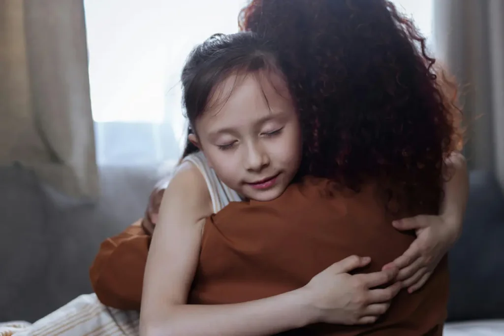 A parent and child sharing a warm, comforting hug