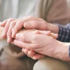 an aged couple hands holding together